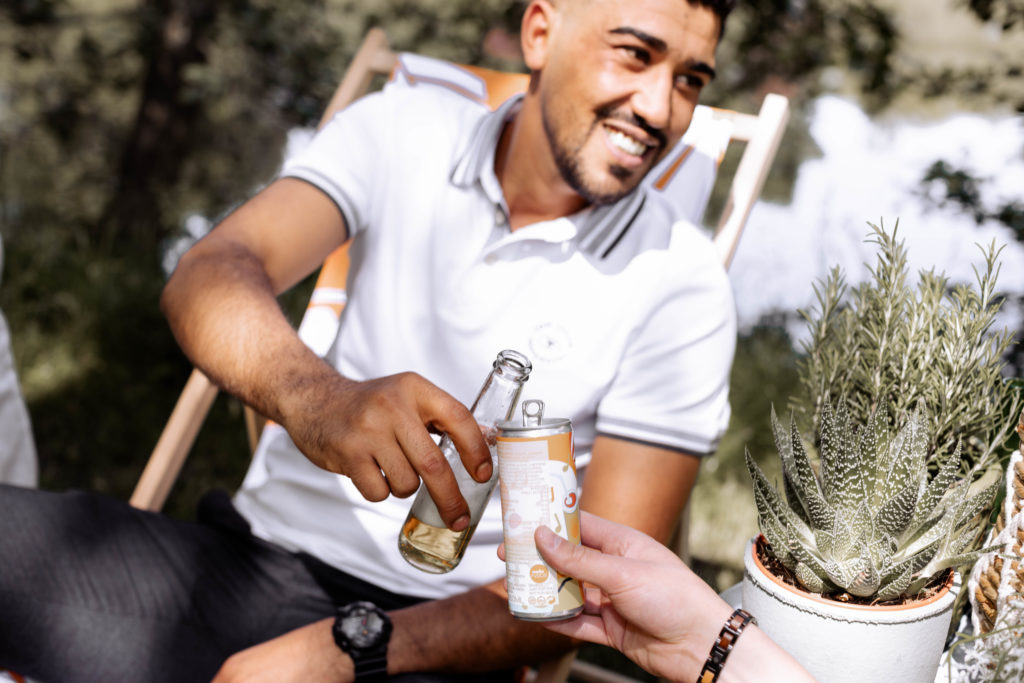 man holds an energy drink with a happy smile